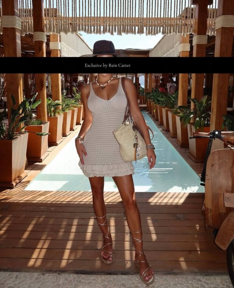 Woman walking through an outdoor corridor wearing a beige dress