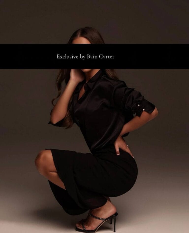 Woman crouching while wearing a short black dress.