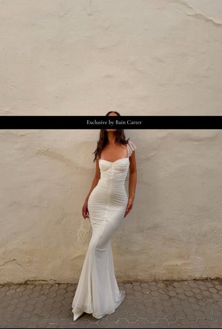 White long dress photographed against a plain wall