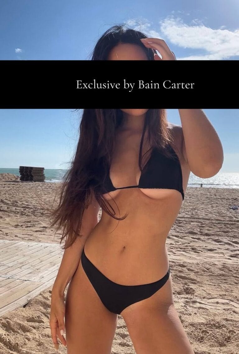 Black bikini photographed on a sandy beach beside the sea