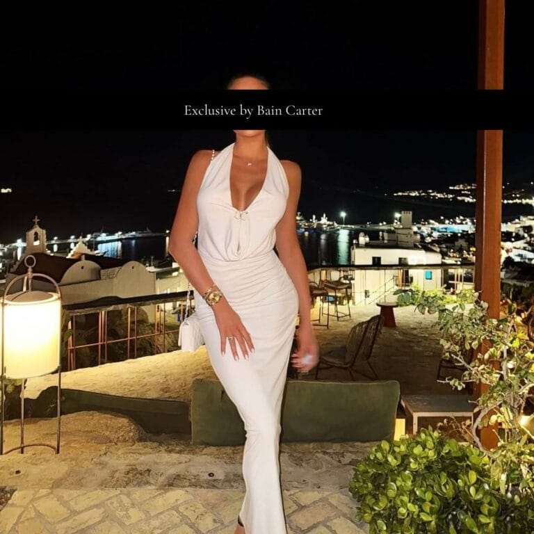 Katerina wearing a white dress overlooking Mykonos at night.