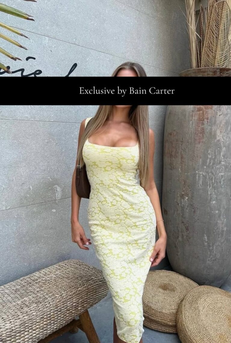 Woman wearing a light-coloured fitted dress standing indoors