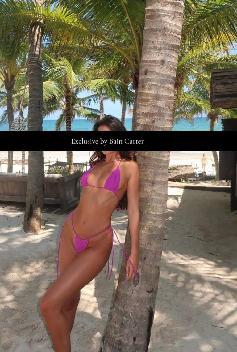 Pink bikini worn by a woman standing beside a palm tree on the beach