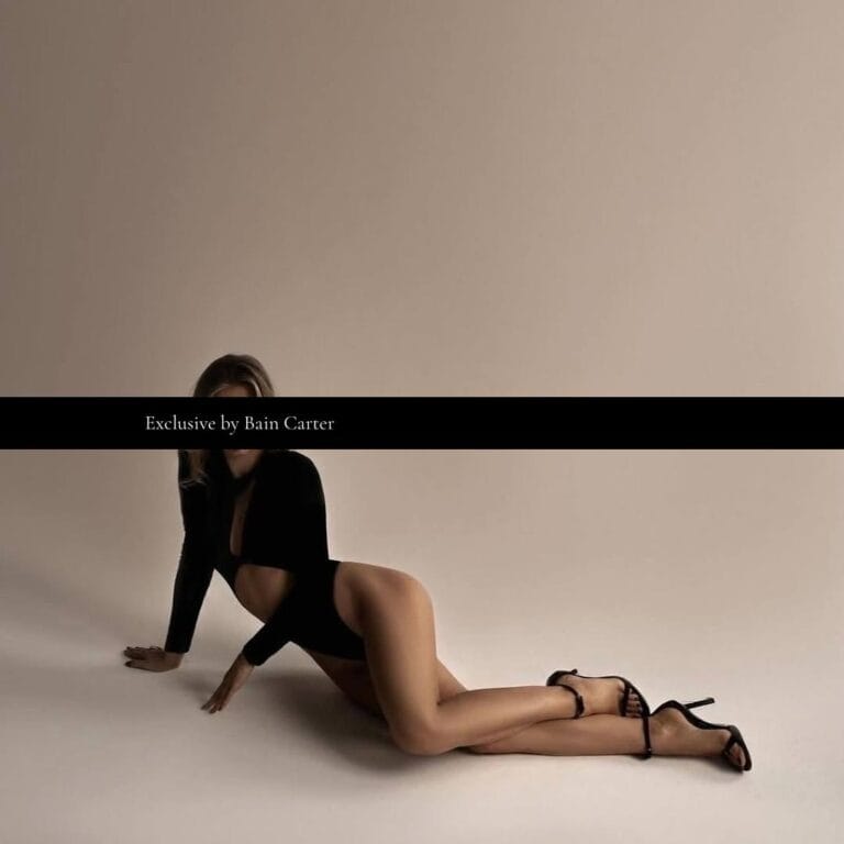 Valeriya posing in a black outfit against a neutral studio background