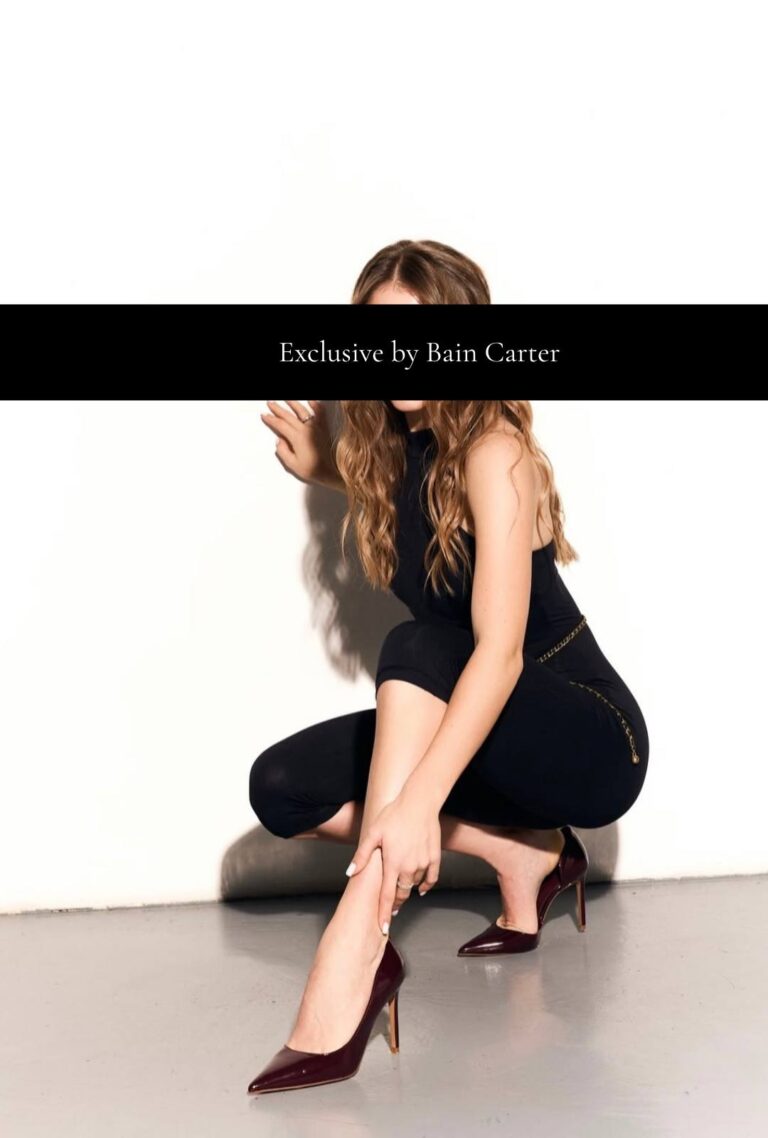 Michaela posing in black heels for her Paris escort profile.