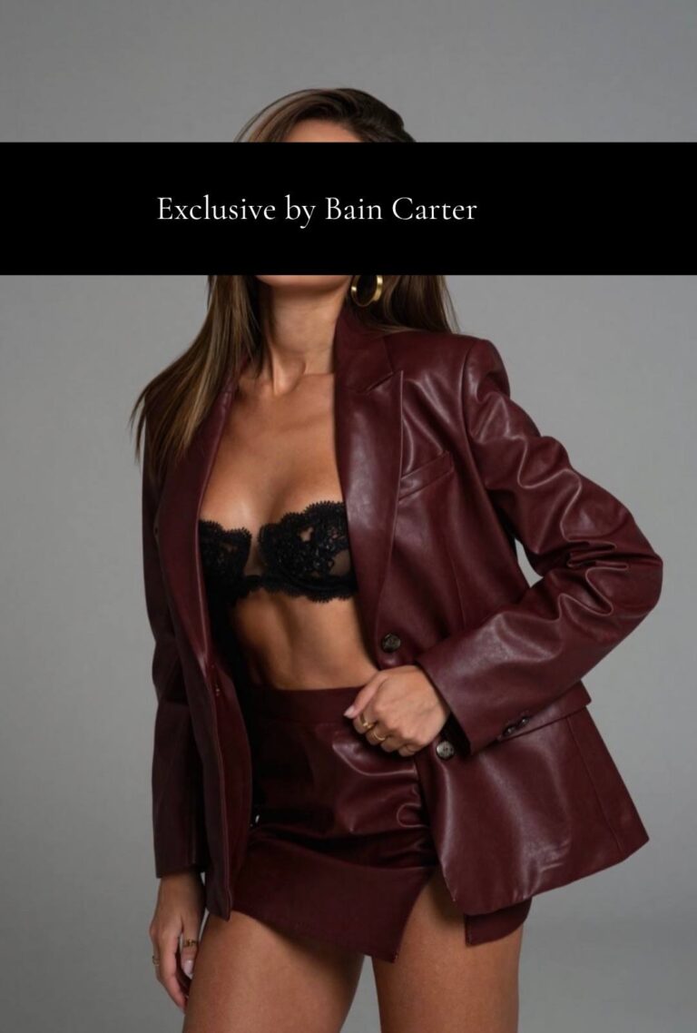 Vittoria posing in a burgundy leather jacket and black lingerie