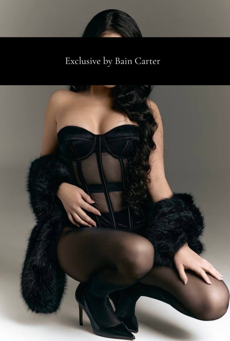 Stefania with long dark hair wearing a black corset