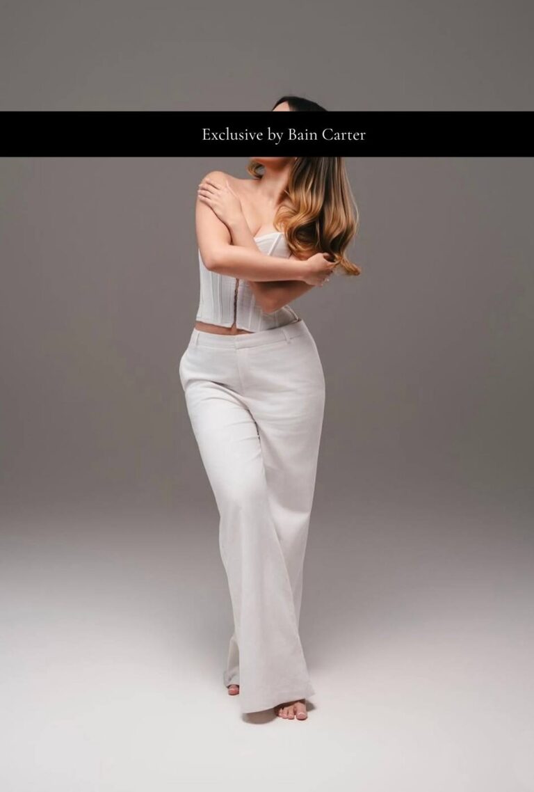 Antonella wearing a white fitted dress