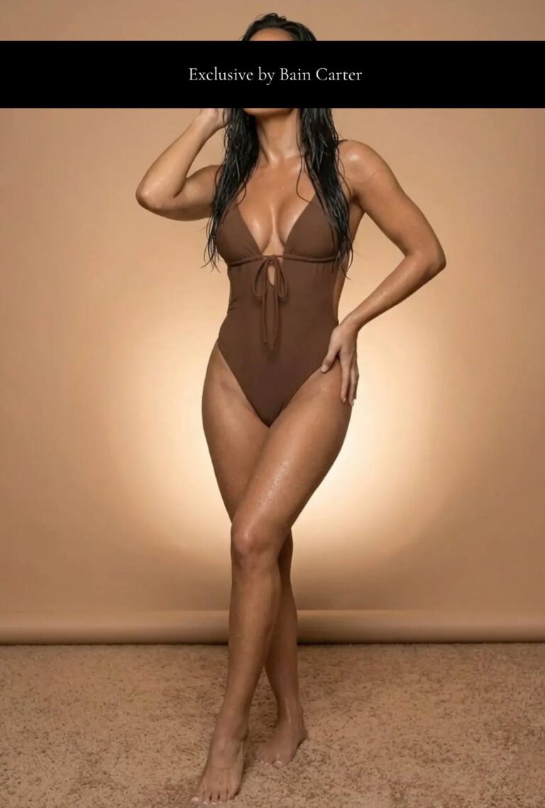 María José sentada con bañador marrón y una pierna elevada