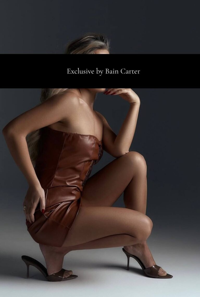 Yuliia crouching in a brown dress and heels